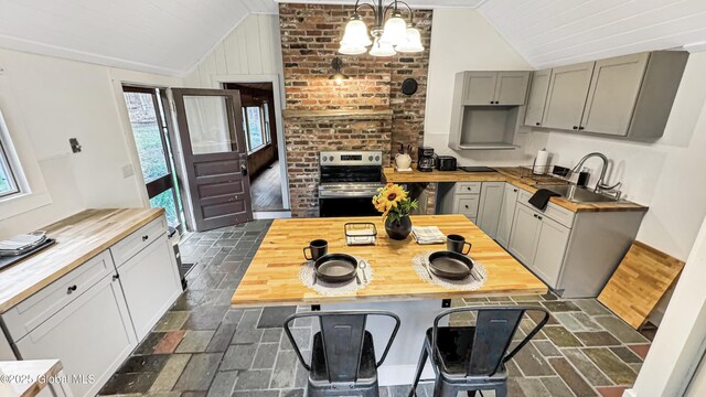 67 Adams Ln, Schroon, NY 12870 - kitchen featuring butcher block counters, stainless steel electric range, vaulted ceiling, a sink, and gray cabinetry