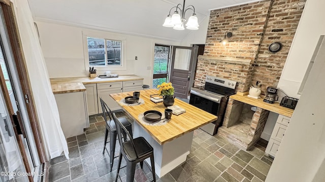 67 Adams Ln, Schroon, NY 12870 - kitchen with butcher block counters, electric stove, a chandelier, decorative light fixtures, and vaulted ceiling