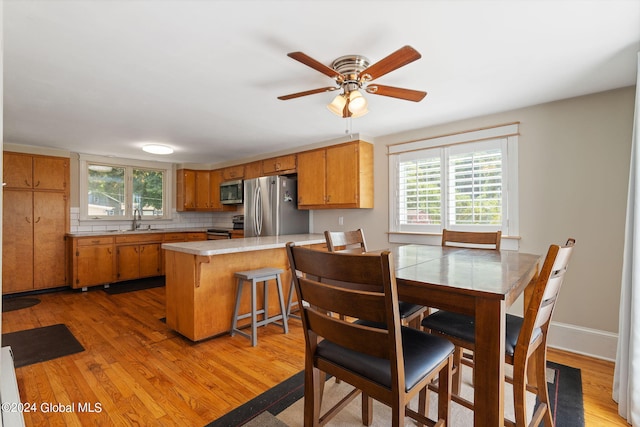 kitchen featuring stainless steel appliances, sink, kitchen peninsula, and light hardwood / wood-style floors