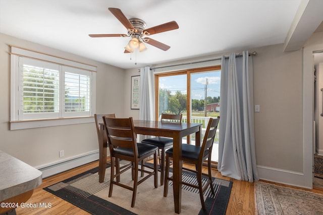 dining area with hardwood / wood-style floors, ceiling fan, and baseboard heating