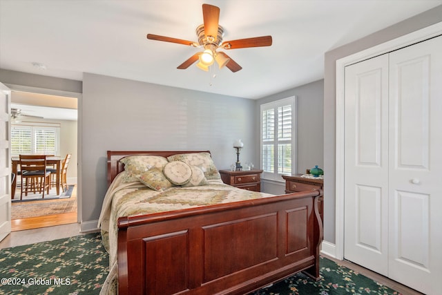 bedroom with ceiling fan, a closet, multiple windows, and light wood-type flooring