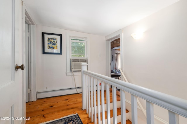 hallway featuring baseboard heating, lofted ceiling, light hardwood / wood-style floors, and cooling unit