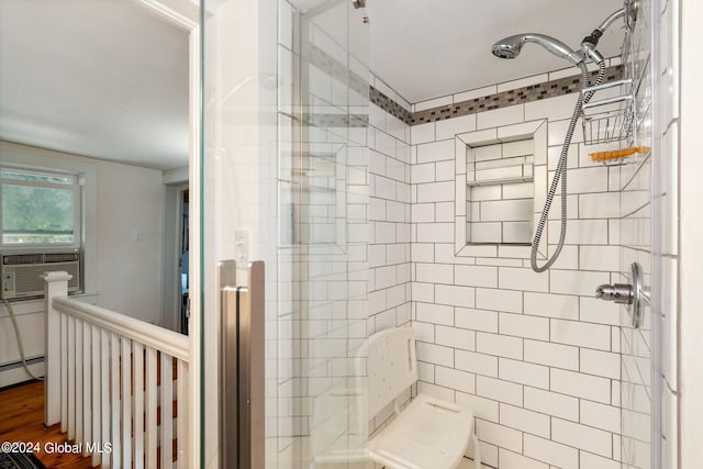 bathroom with a baseboard radiator, wood-type flooring, cooling unit, and walk in shower