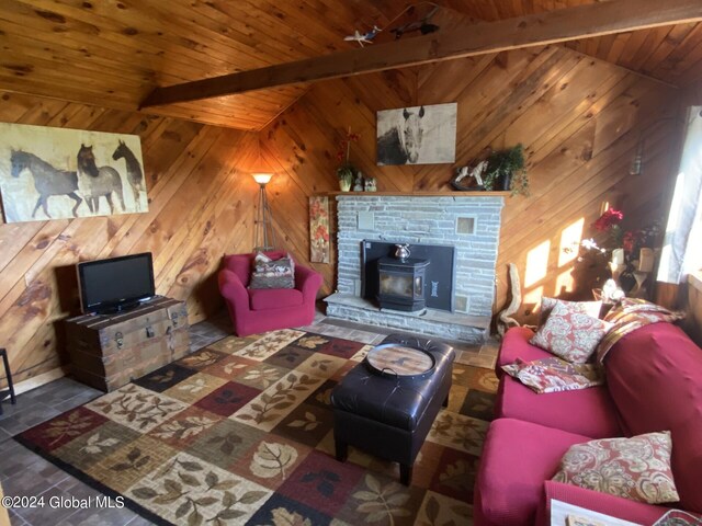 living room with lofted ceiling with beams, a wood stove, and wood ceiling