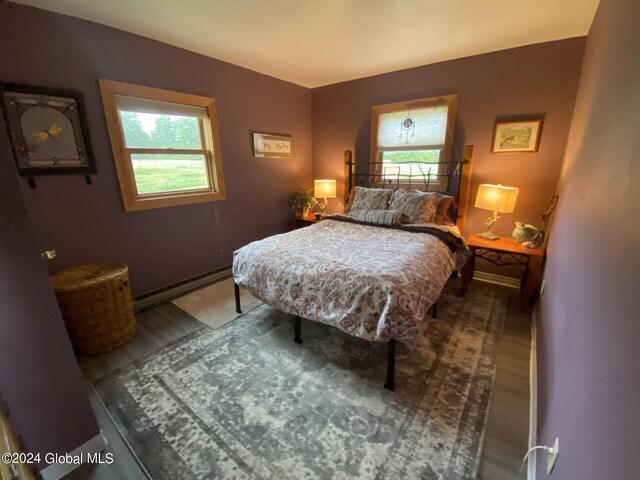 bedroom featuring wood-type flooring and a baseboard radiator