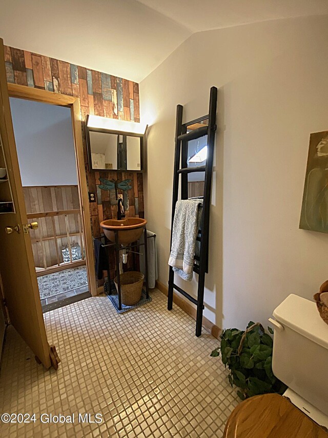 bathroom featuring toilet, lofted ceiling, and sink