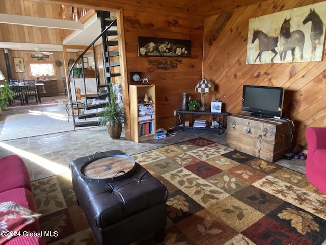 living room with ceiling fan, wooden walls, wood ceiling, and lofted ceiling