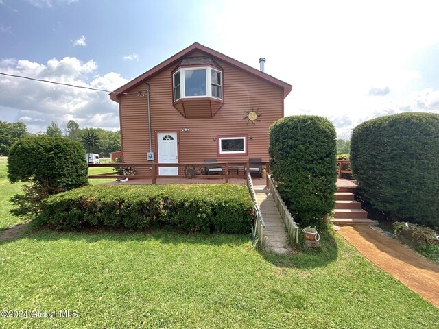 rear view of property with a lawn and a wooden deck