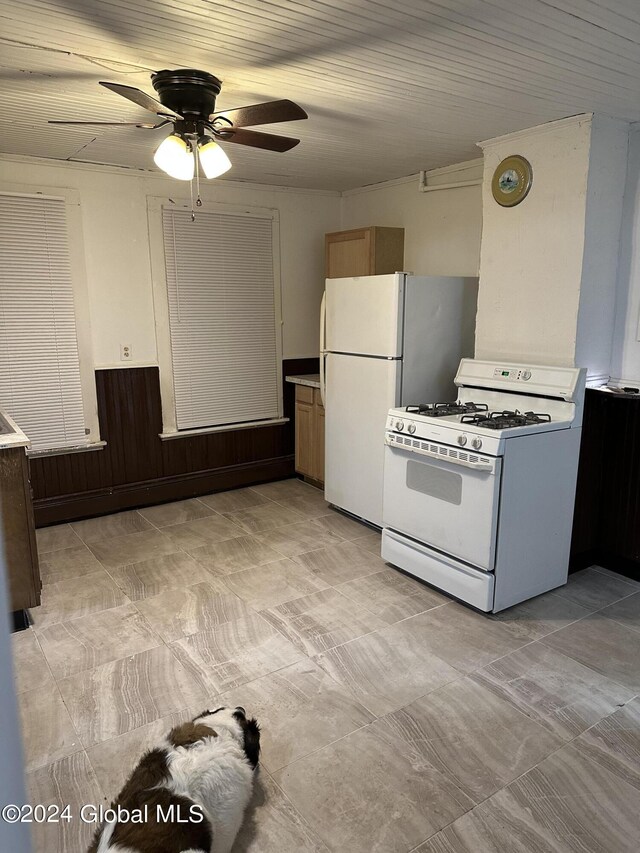 kitchen featuring ceiling fan, wood walls, and white appliances