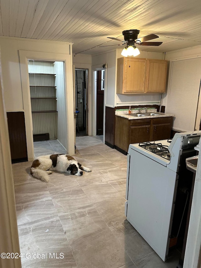 kitchen with ceiling fan, white range, and sink