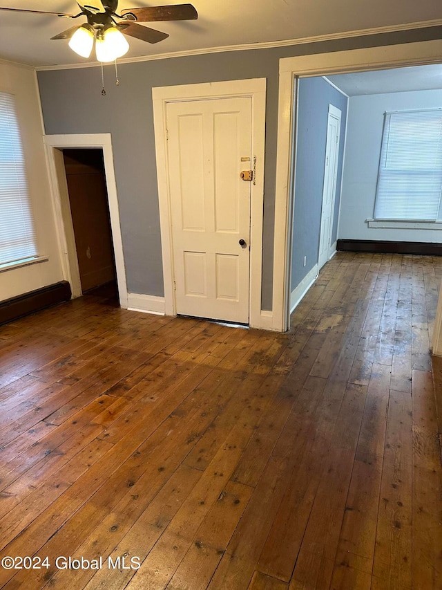 interior space with dark hardwood / wood-style flooring, ceiling fan, and ornamental molding