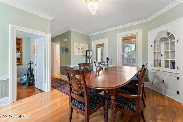 dining area with ornamental molding, hardwood / wood-style floors, and a chandelier