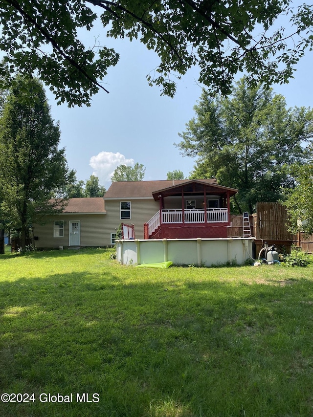 back of property featuring a yard and an outdoor pool