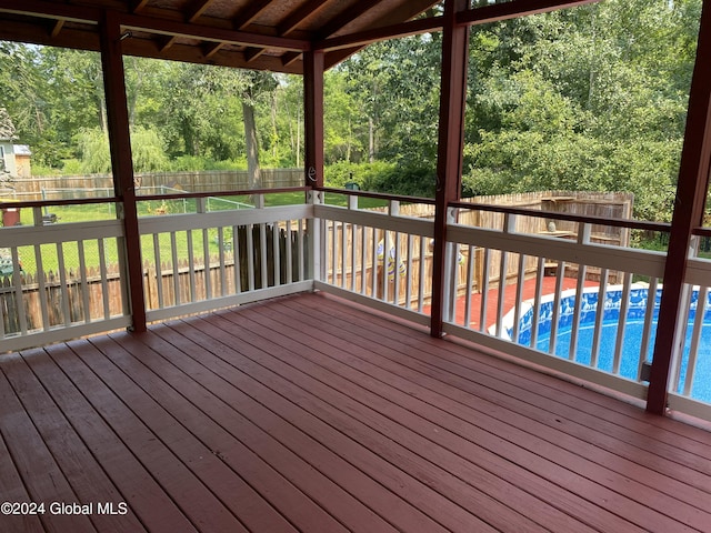 wooden deck with a fenced in pool and a fenced backyard