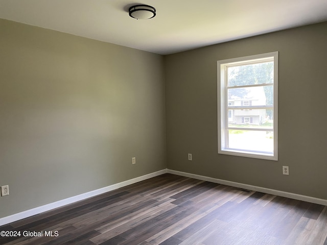 unfurnished room featuring dark wood-style floors and baseboards