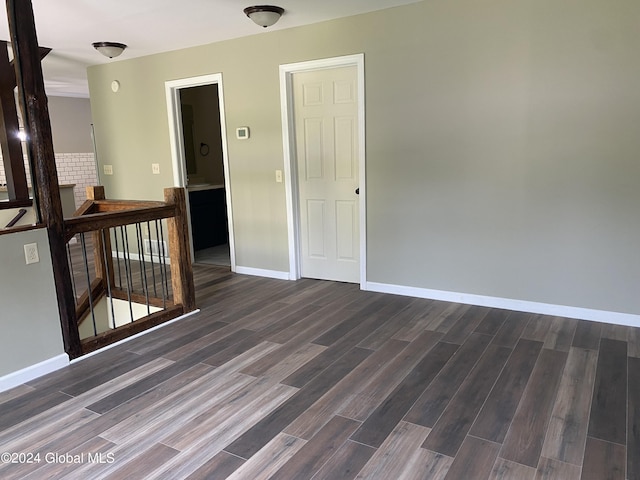 empty room with dark wood-style floors and baseboards