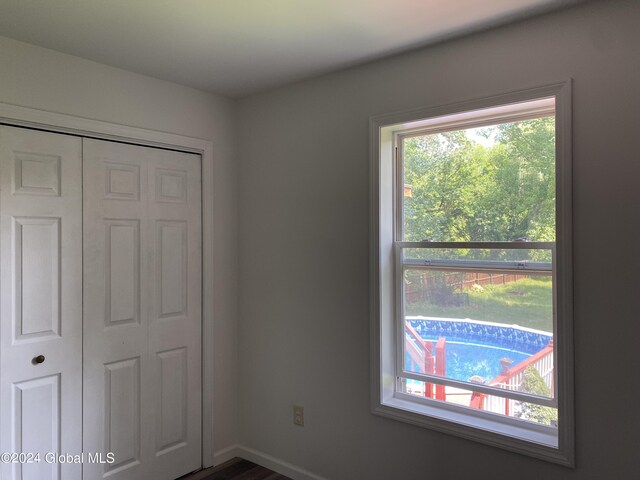 unfurnished bedroom with multiple windows and a closet