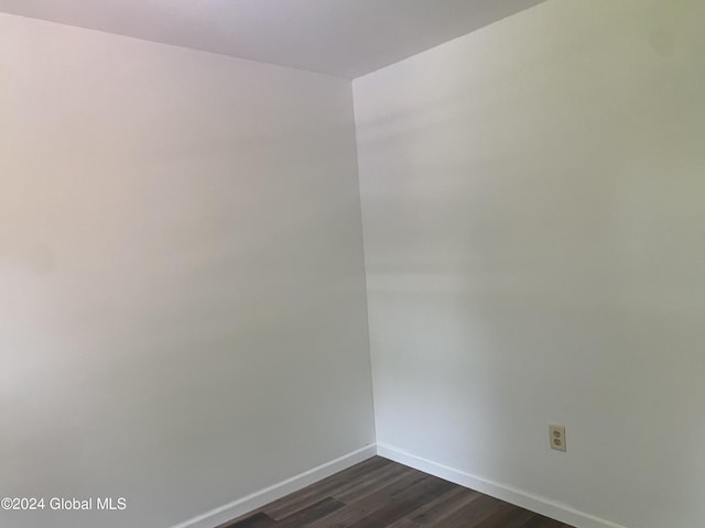 empty room featuring dark wood-style floors and baseboards