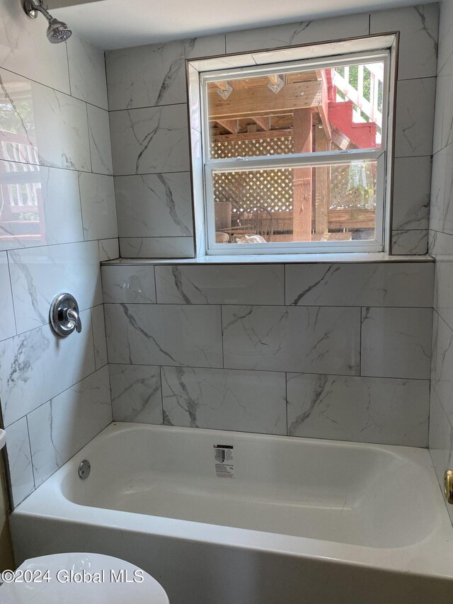 bathroom with shower / bathing tub combination and toilet