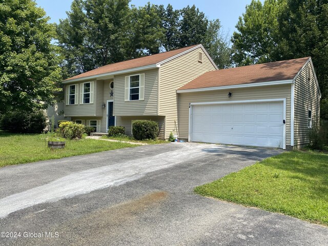 split foyer home with a garage and a front lawn