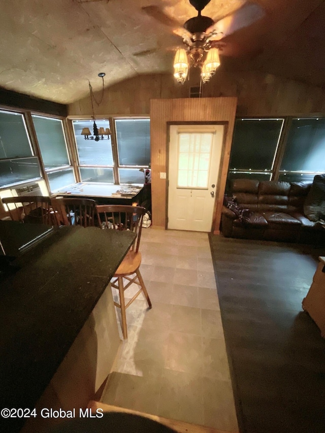 dining room with a notable chandelier and vaulted ceiling