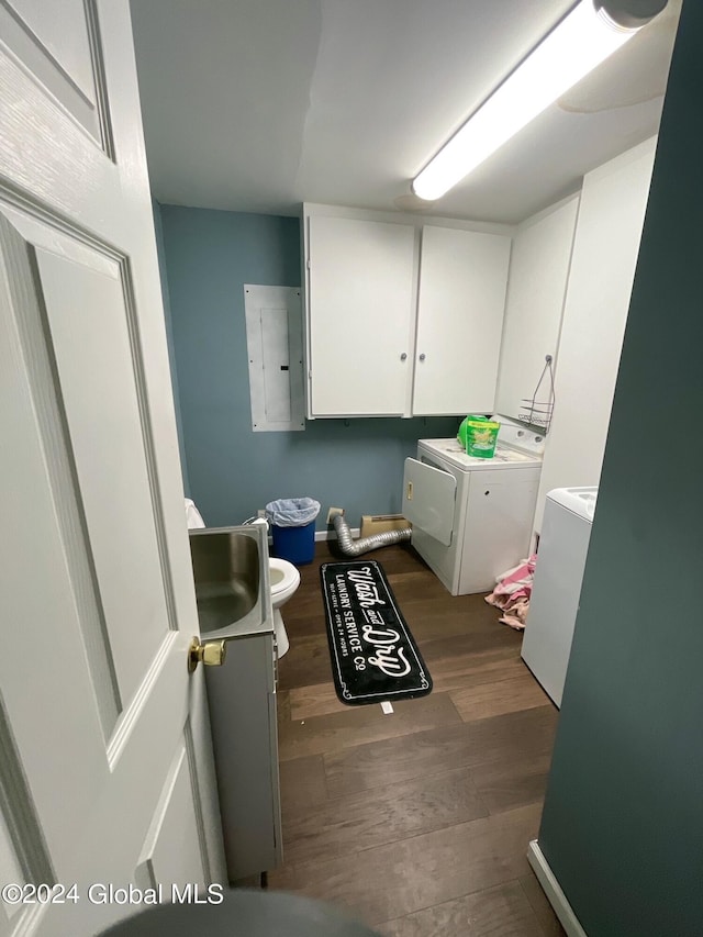 interior space with vanity, hardwood / wood-style floors, washing machine and dryer, and electric panel