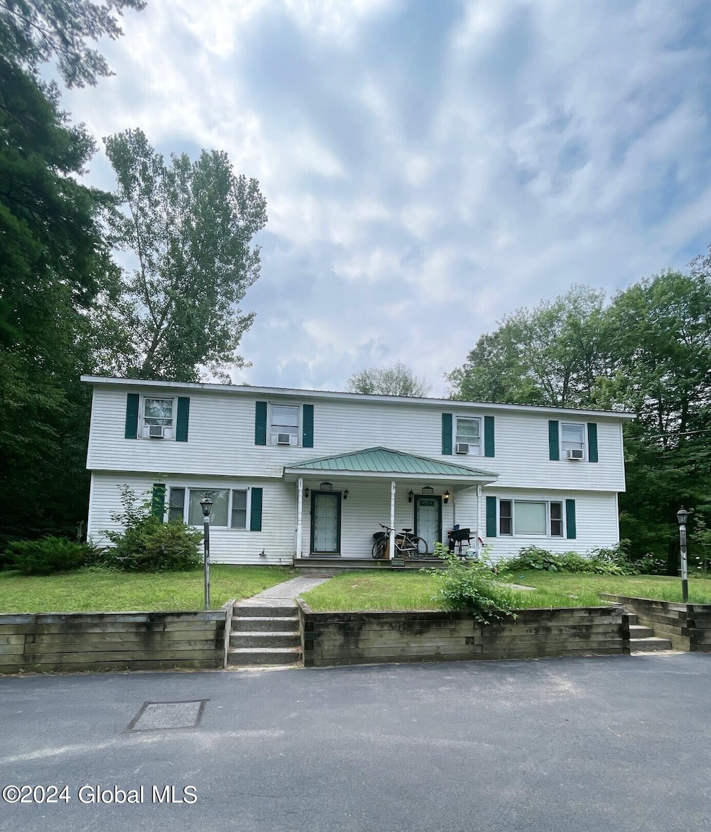 view of front of home with a porch and a front lawn