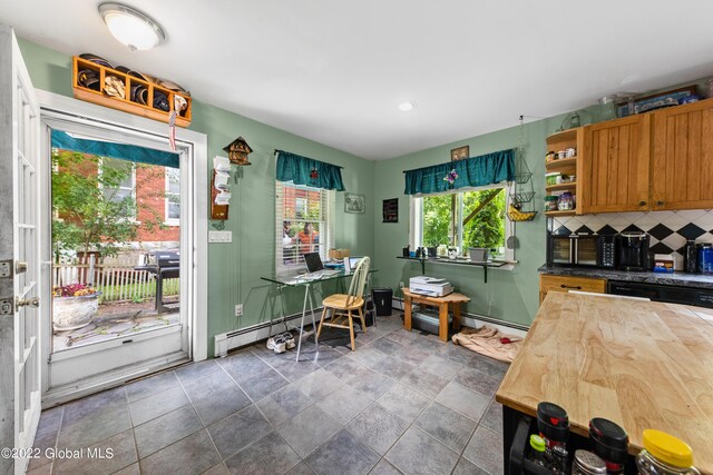 kitchen with a baseboard radiator, tile patterned flooring, tasteful backsplash, and butcher block counters