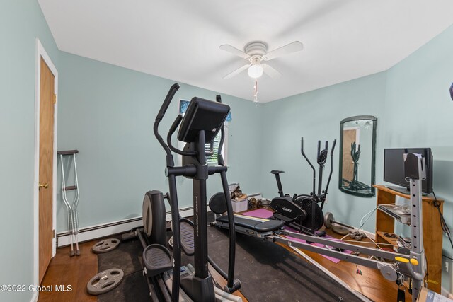 exercise room with a baseboard radiator and ceiling fan