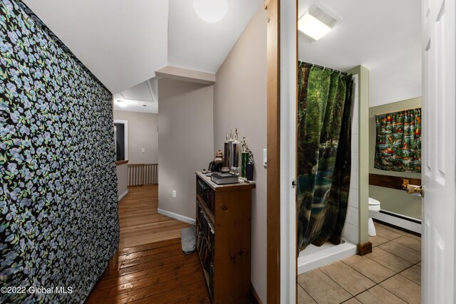 corridor featuring baseboard heating and light hardwood / wood-style floors