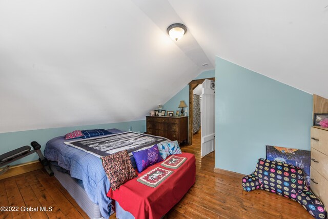 bedroom with wood-type flooring and lofted ceiling