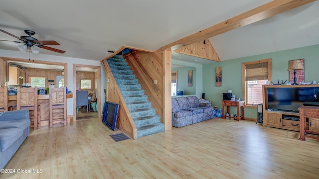 living room featuring light hardwood / wood-style flooring, lofted ceiling with beams, and ceiling fan