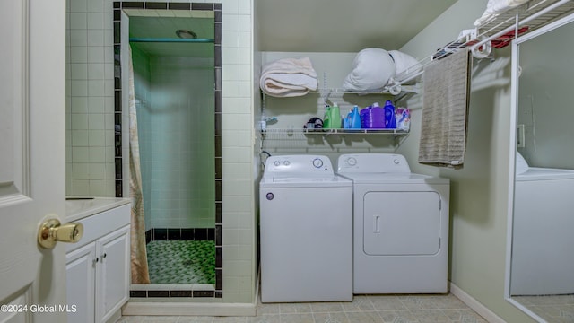 laundry area with washing machine and clothes dryer and light tile patterned flooring