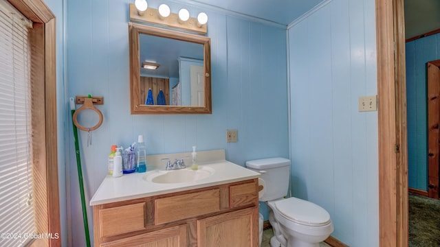 bathroom featuring vanity, ornamental molding, and toilet