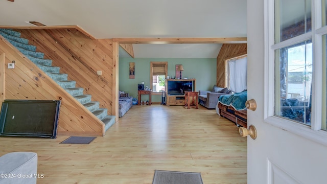 interior space with plenty of natural light, wooden walls, and light hardwood / wood-style flooring