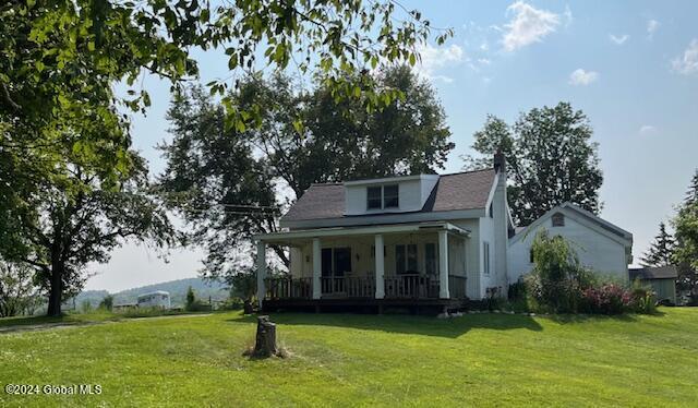 view of front of house featuring covered porch and a front lawn