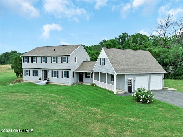 colonial house featuring an outdoor structure, a garage, and a front yard