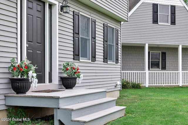 doorway to property featuring a lawn