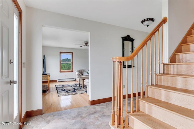 stairway featuring a baseboard radiator, light hardwood / wood-style flooring, and ceiling fan