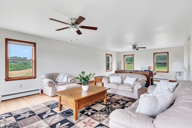 living room featuring plenty of natural light, a baseboard heating unit, light wood-type flooring, and ceiling fan