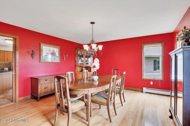 dining room with light hardwood / wood-style floors, baseboard heating, and a chandelier