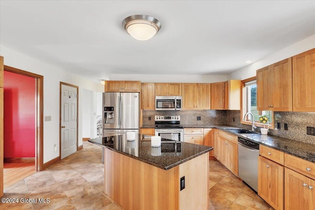 kitchen with light tile patterned floors, a kitchen island, stainless steel appliances, decorative backsplash, and sink