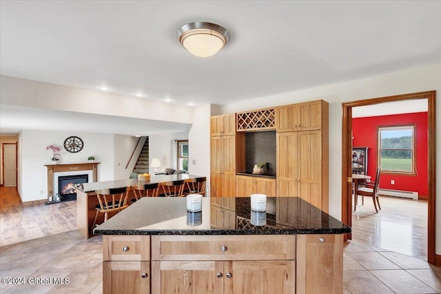 kitchen featuring light hardwood / wood-style flooring, baseboard heating, and a kitchen island