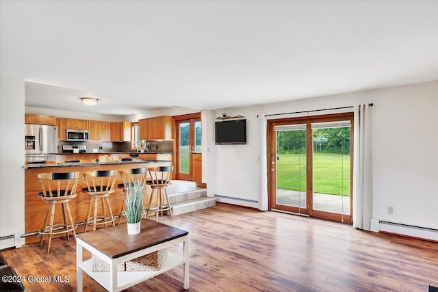 living room featuring a baseboard heating unit and light hardwood / wood-style floors