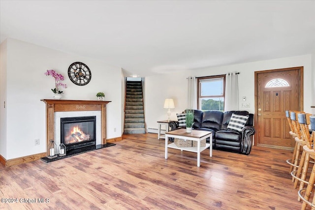 living room featuring a baseboard heating unit and hardwood / wood-style floors