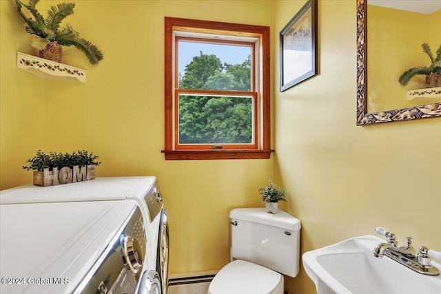 bathroom featuring sink, washer and clothes dryer, toilet, and a baseboard radiator