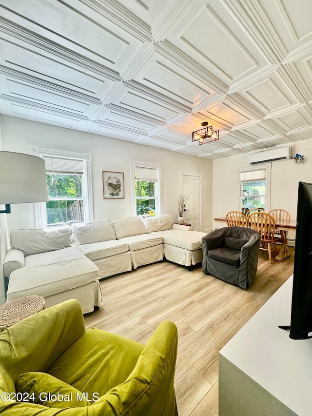 living room featuring an AC wall unit, light wood-type flooring, and coffered ceiling