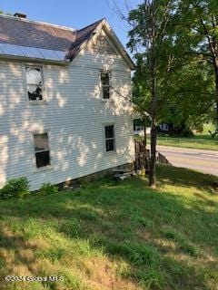 view of side of property with a lawn