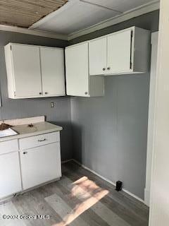 kitchen with dark hardwood / wood-style flooring and white cabinets