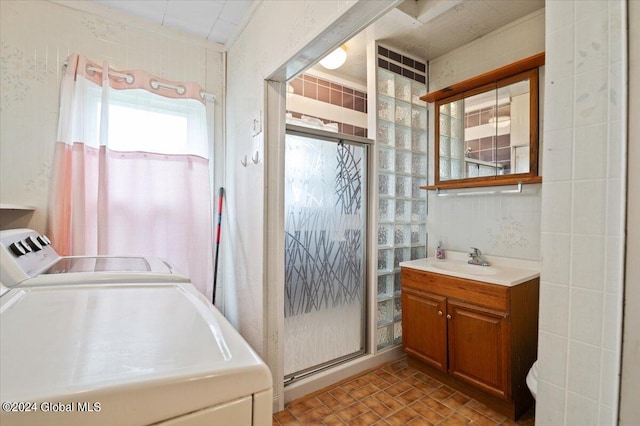 washroom featuring sink, light tile patterned flooring, and independent washer and dryer